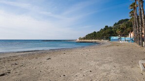 A beach with a rocky shoreline, a clear sky, and a few buildings in the background. - 2 bedroom stunning apartment in Taggia (Taggia)