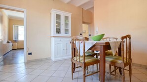 A dining area with a wooden table and chairs, a cabinet, and a view into another room. - 2 bedroom stunning apartment in Taggia (Taggia)