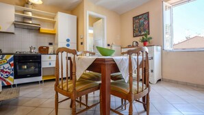 A kitchen with a dining table, chairs, a stove, and a window. - 2 bedroom stunning apartment in Taggia (Taggia)