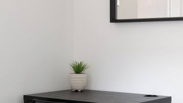 Una habitación minimalista con un escritorio, una silla y una planta en maceta.