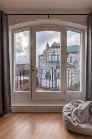 Een kamer met een groot raam met uitzicht op een historisch gebouw.
