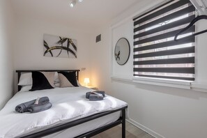 1 dormitorio, escritorio, tabla de planchar con plancha y cuna de viaje