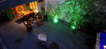 An outdoor patio with a dining area, chairs, and a small white toilet.