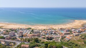 Un pueblo costero con playa, edificios y una carretera.
