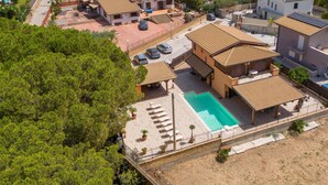 Zona residencial con piscina, varias casas y un árbol grande.