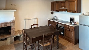 A kitchen with wooden cabinets, a built-in oven, a sink, and a refrigerator.
