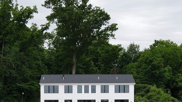 A modern two-story building with a dock and a boat. - Luxury 6BR Round Lake Home Pool, Dock, Fire Pit & Stunning Sunsets!. (Dowagiac)