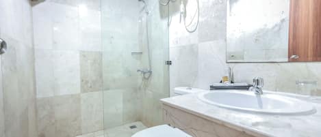 A bathroom with a toilet, a sink, and a shower.