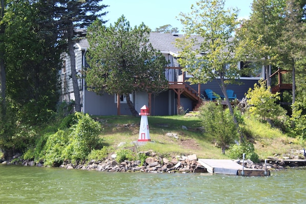 A lakeside property with a dock, a lighthouse, and a house with a deck and stairs. - Rent for a month or the winter for substantially less than summer prices! (South frontenac)
