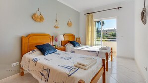 Ein Hotelzimmer mit zwei Betten, einem großen Fenster mit Blick und einem Balkon.