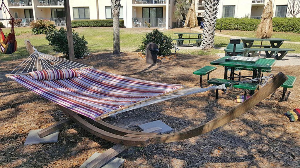 Een hangmat in een park met picknicktafels en banken.