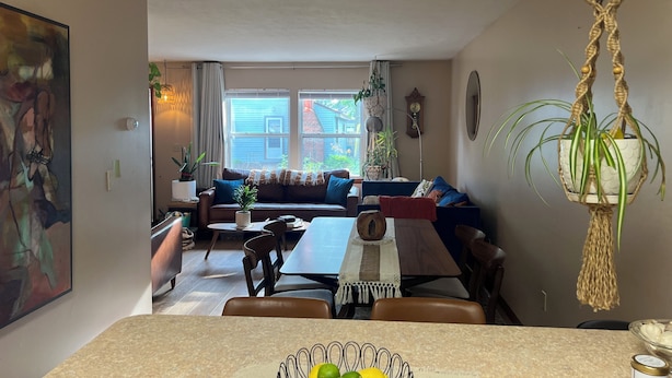 A cozy living room with a sofa, a dining table, and a kitchen area. - Cozy Vibe, Clean, Beach Access, 10 mins to GOTL! (Ashtabula)