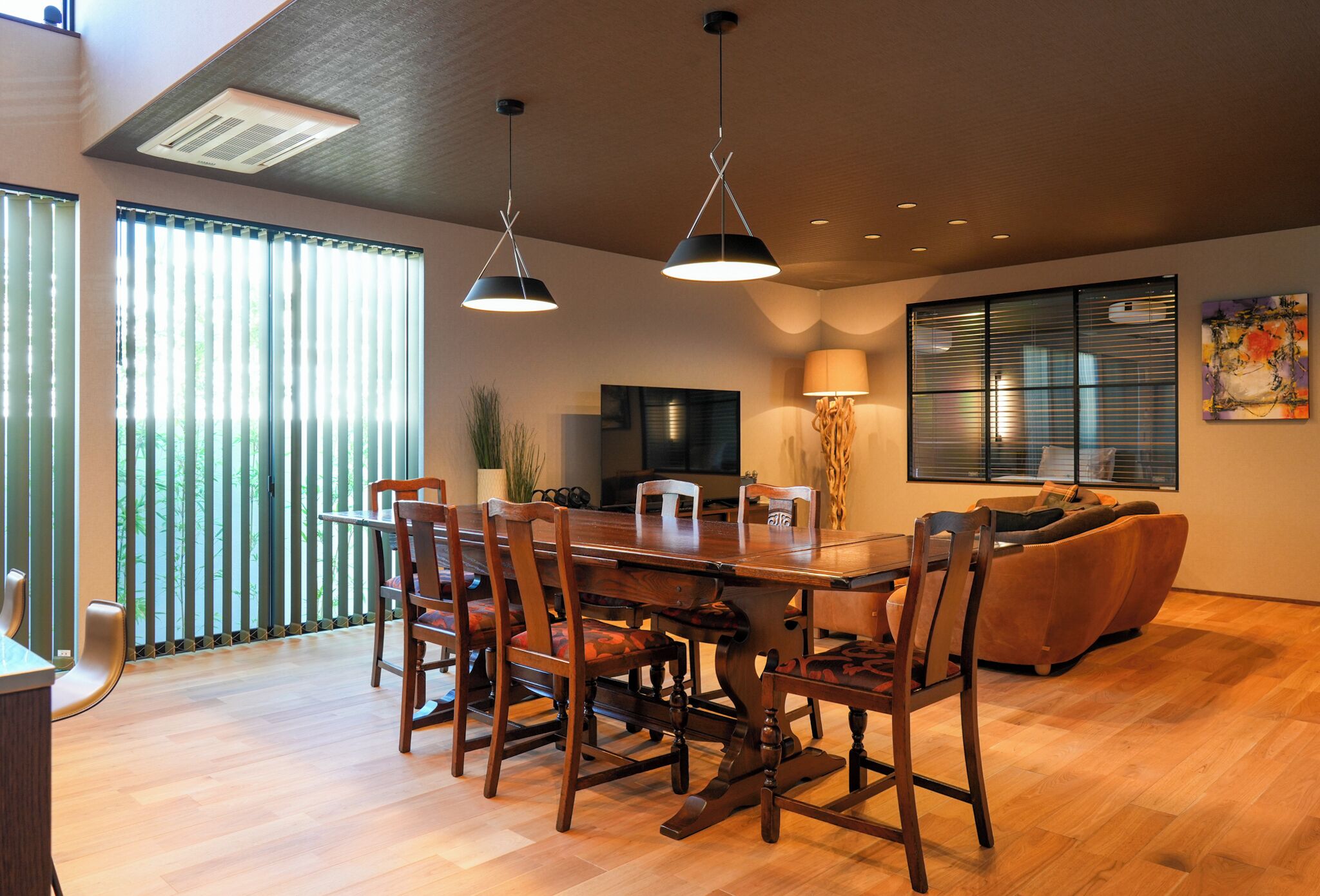 Un comedor con una mesa y sillas de madera, un sofá y un televisor.