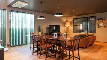 Un comedor con una mesa y sillas de madera, un sofá y un televisor.