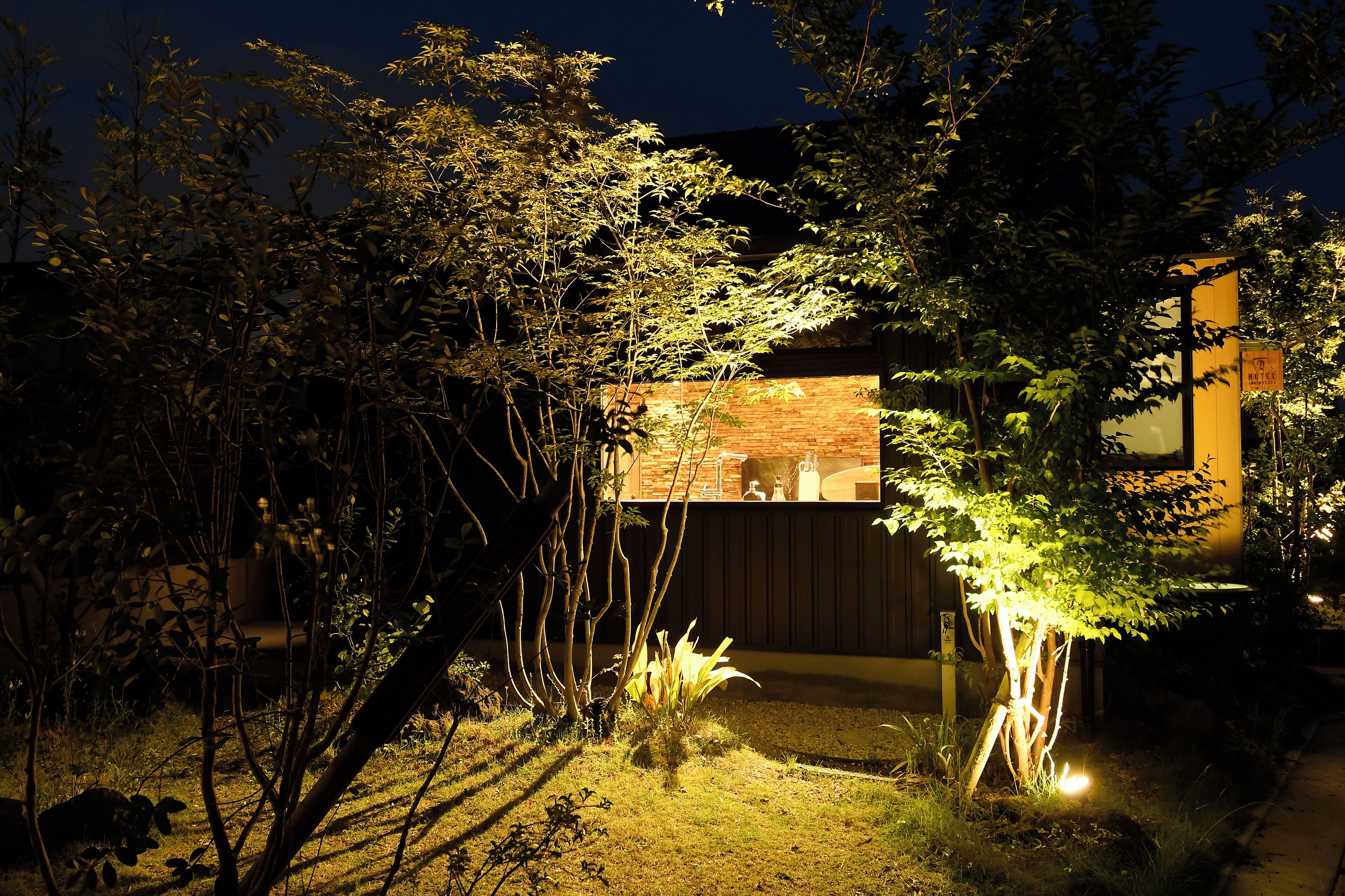 Una casa moderna con un muro de ladrillo y una terraza de madera.