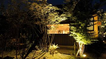 Una casa moderna con un muro de ladrillo y una terraza de madera.