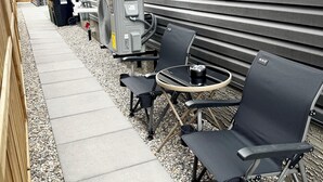 En utomhusplats med en grill, sittplatser och en gångväg.