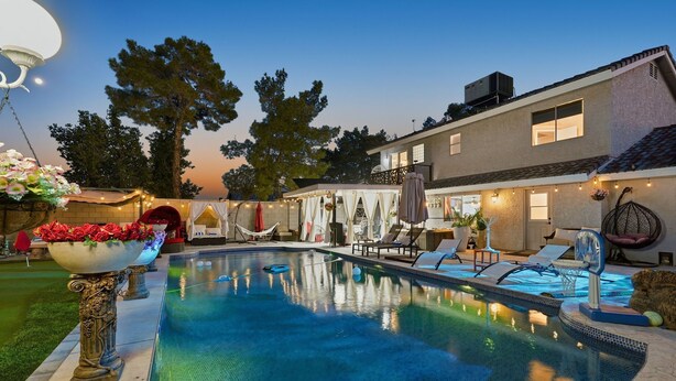 A swimming pool with a fountain, surrounded by lounge chairs and a covered seating area. - Spacious 4-bedroom house with WiFi and AC in fantastic Chandler (Chandler)