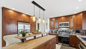A modern kitchen with wooden cabinets, stainless steel appliances, and pendant lighting. - Spacious 4-bedroom house with WiFi and AC in fantastic Chandler (Chandler)
