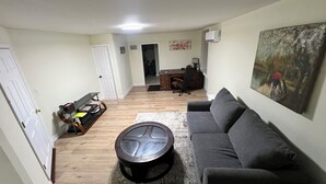 A living room with a gray sofa, a round coffee table, and a painting on the wall.