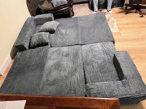 A room with a large sectional sofa, a wooden coffee table, and a small round table with chairs. - Cozy 1-bedroom apartment with WiFi, AC in welcoming North Bergen (North Bergen)