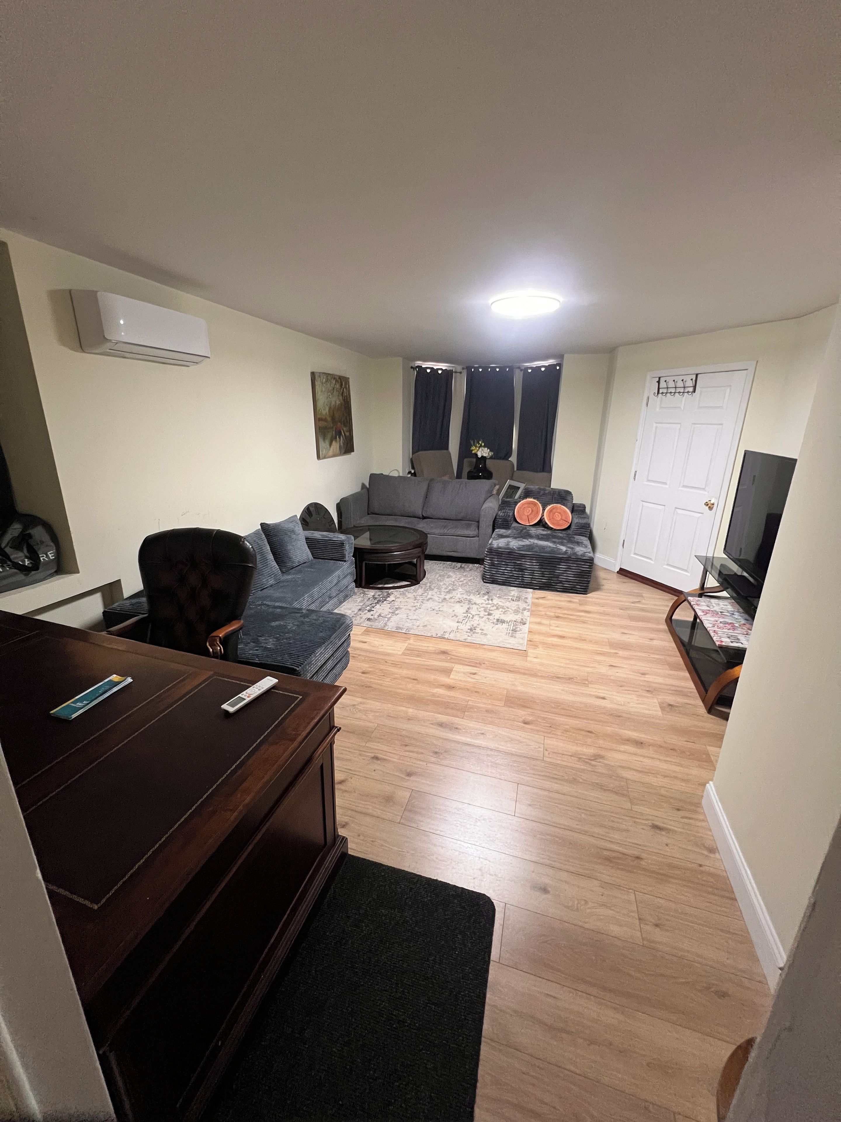 Una sala de estar con sofá, mesa de centro, televisor y piano.