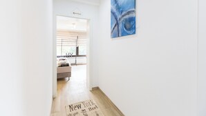 A hallway with a sign reading "New York" and a large abstract painting on the wall.