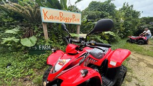 Un quad rouge est garé près d’un panneau indiquant « KabiraBuggyPark » et « 5 FARM ».