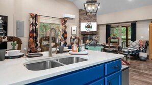 A modern kitchen with a large island, built-in appliances, and a stone accent wall. - Ultimate Couples Escape w/ Hot Tub & Firepit + Free Family Tickets (Hollister)