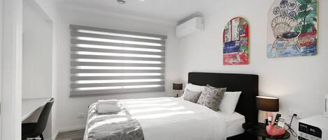 Escritorio, tabla de planchar con plancha, wifi y ropa de cama