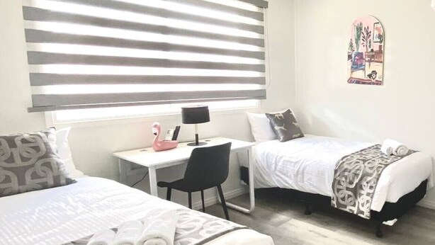 Une chambre avec deux lits, un bureau et une chaise.