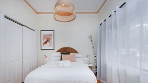 A bedroom with a large bed, white curtains, a hanging light fixture, and a framed picture on the wall. - 2BR Home with Private Backyard, Free Parking, Fast Wi-Fi - 3-Min Walk to Yarraville Village (Yarraville)
