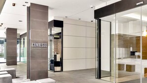 A modern building entrance with a sign reading "CONVESSD 8 WATERSIDE PLACE". - Luxurious Docklands Escape| 1BR Apartment with Pool, Gym, Sauna, Balcony & Fast Wi-Fi (Docklands)