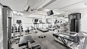 A modern gym with various exercise equipment, including treadmills, weight machines, and free weights.