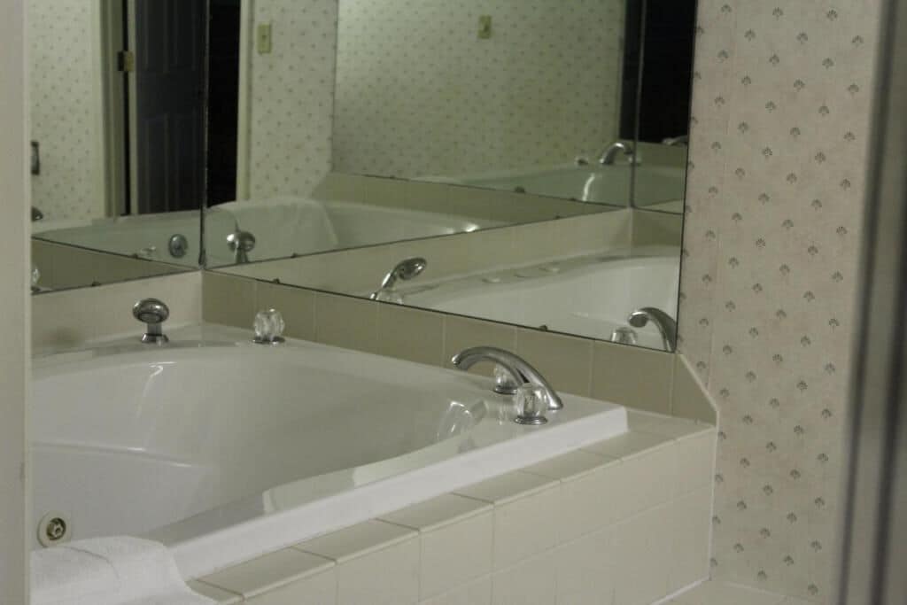 Un baño con un espejo grande, una bañera y un lavabo.