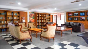 A library with bookshelves, a coffee table, and a sofa. - Puri Saras Syariah (Lembang)