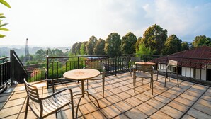A terrace with a view of the Eiffel Tower, featuring outdoor seating and a railing. - Puri Saras Syariah (Lembang)