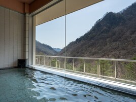 A room with a large window overlooking a mountainous landscape.