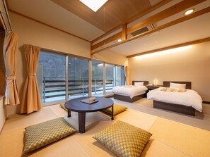 A modern hotel room with two beds, a round table, and large windows offering a view of the outdoors. - Ashionoyado Kajika (Nikko)