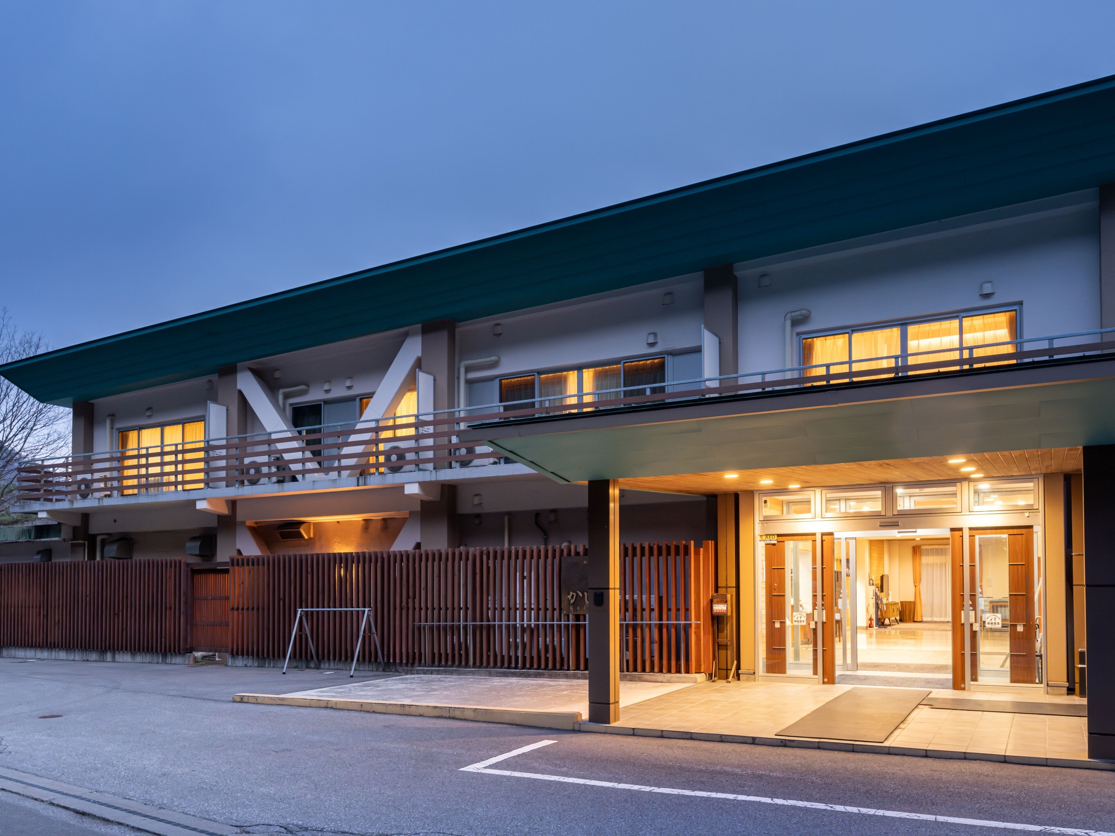 A modern two-story building with a flat roof and a balcony.