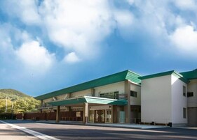 Un bâtiment moderne doté d’un toit végétalisé, d’un hall d’entrée abrité et d’un parking.