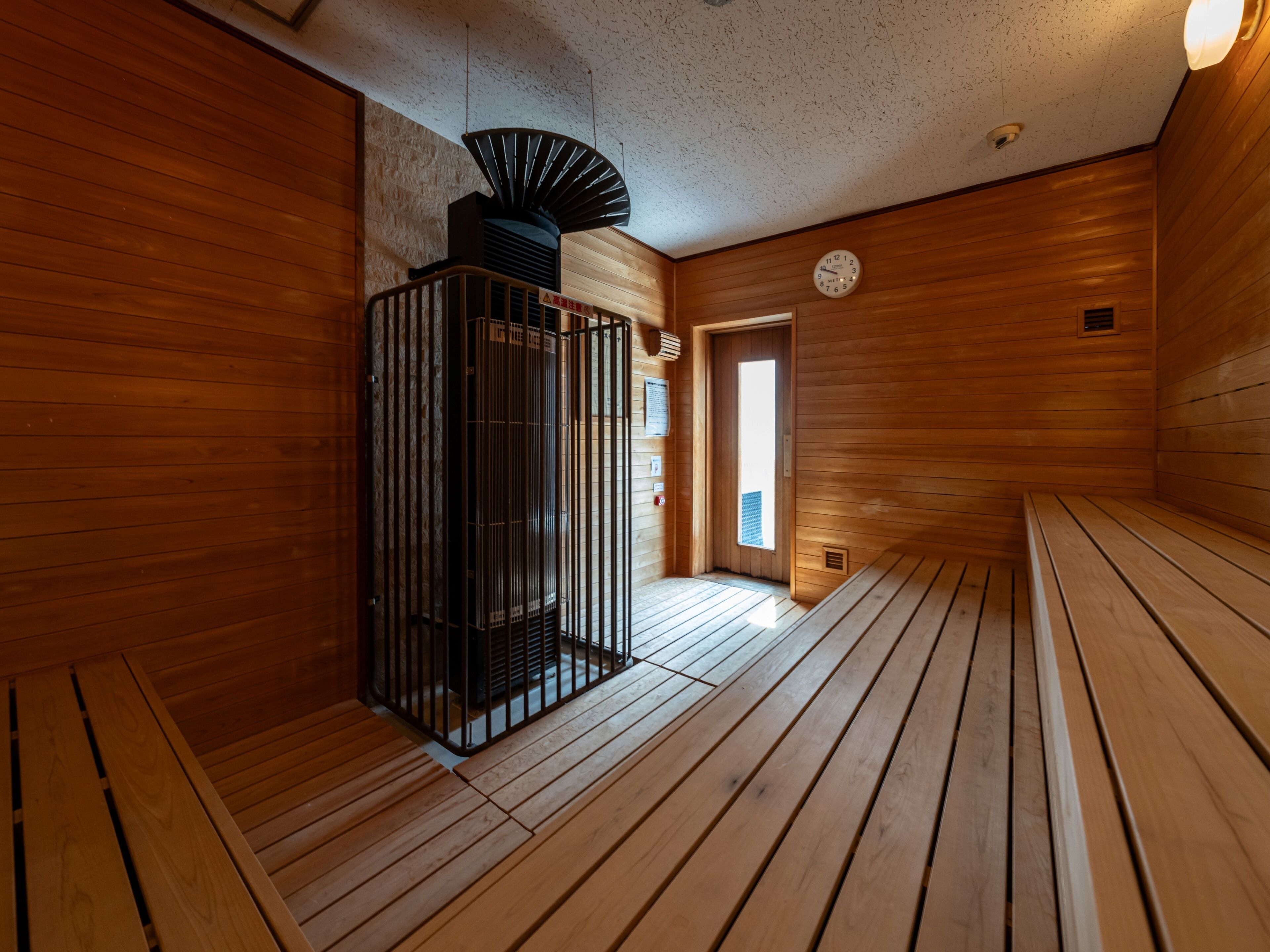 A sauna room with wooden walls and benches.