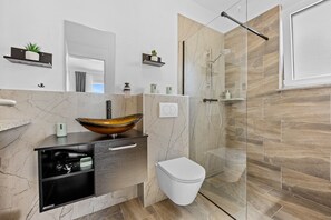 Een douche, een haardroger, handdoeken, toiletpapier