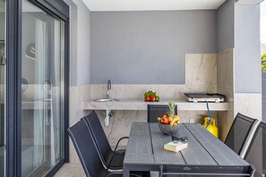 Une cuisine moderne dotée d’un plan de travail en marbre, d’un évier et d’une étagère intégrée.