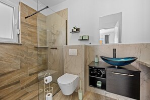 Een douche, een haardroger, handdoeken, toiletpapier