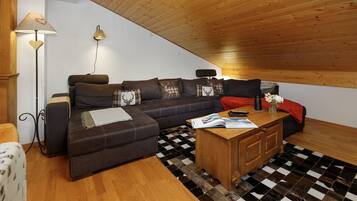 Ein gemütliches Wohnzimmer mit einer Couch, einem Couchtisch und einer Lampe.
