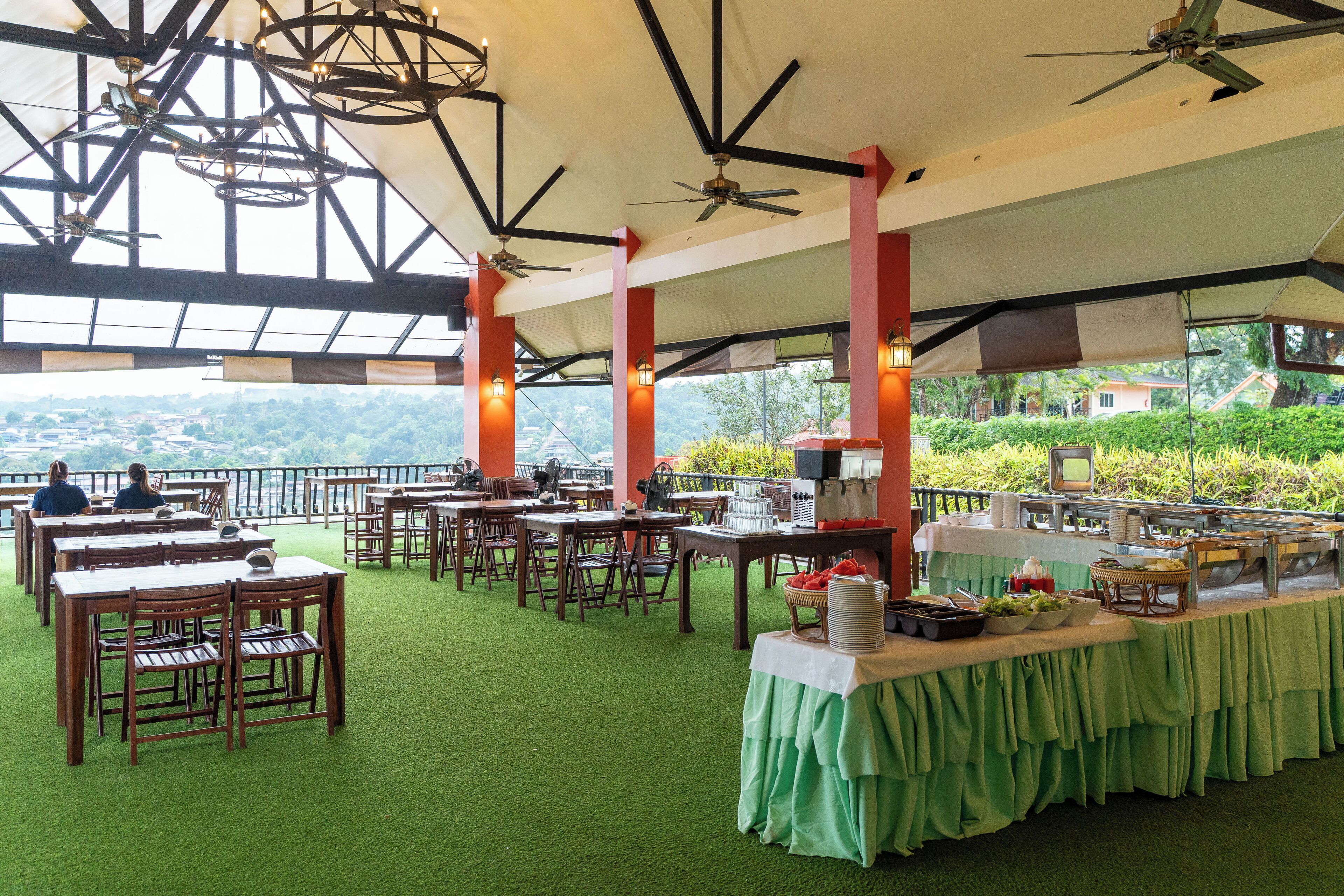 Un restaurant avec des tables et des chaises, un buffet et une vue sur le paysage.