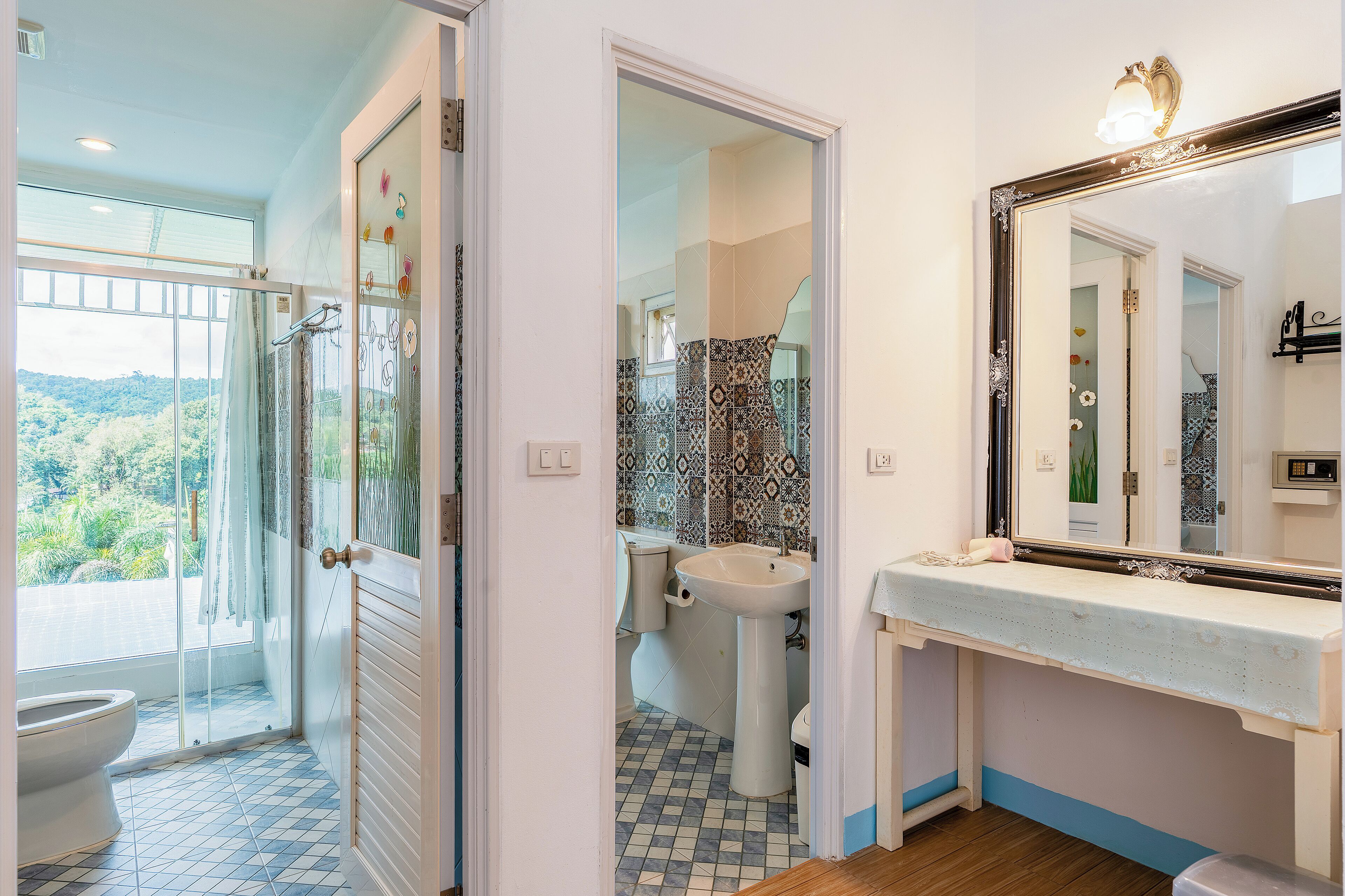Un baño con ducha, inodoro, lavabo y un espejo grande.