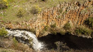 A natural rock formation with a waterfall.