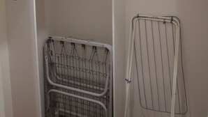 Ett utrymme för tvätt med ett torkställ och en vagn av metall.